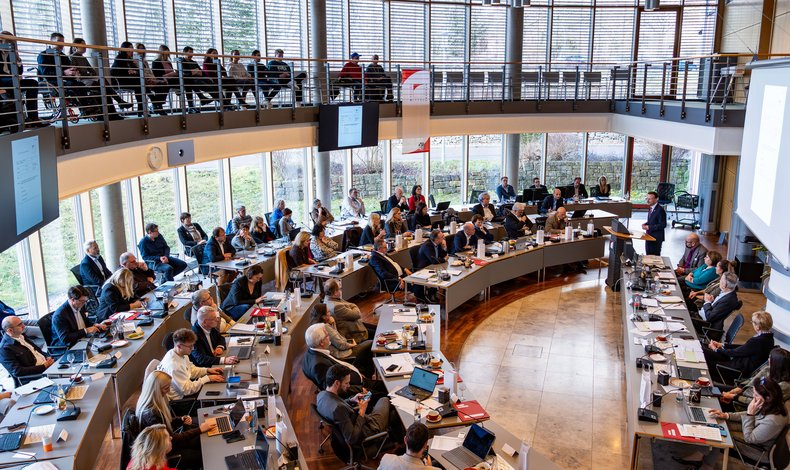 Blick von der Empore des Sitzungssaals nach unten in den voll besetzten Saal während einer Sitzung.