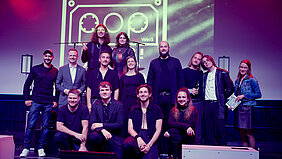 Gruppenbild der Preisträger, Bezirkstagspräsident Peter Daniel Forster und Popularmusikberater Andy Horst auf der Bühne.