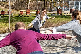 Eine Dame macht eine Übung vor, die Teilnehmer der aktiven MInipause machen die Übung nach.