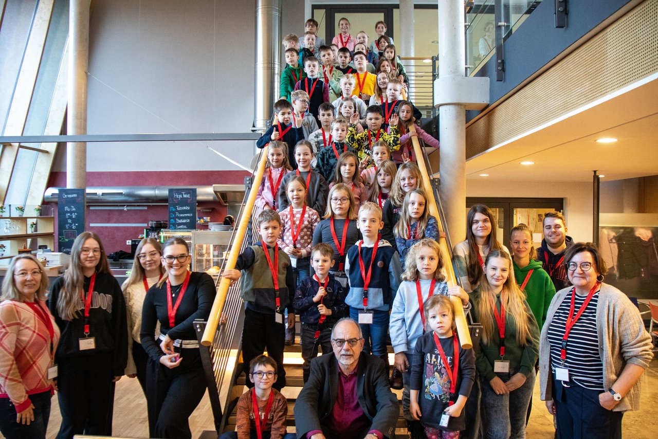 Gruppenfoto vom „Kind-kommt-mit-Tag“ mit allen Kindern und mitwirkenden Beschäftigten der Bezirksverwaltung in der Cafeteria des Bezirksrathauses.