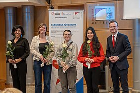 Fünf Personen stehen vor einem Roll-Up