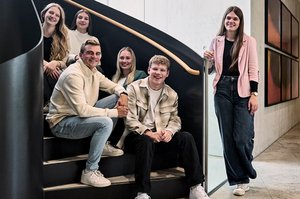 Gruppenbild verschiedener Nachwuchskräfte vor einer Treppe.