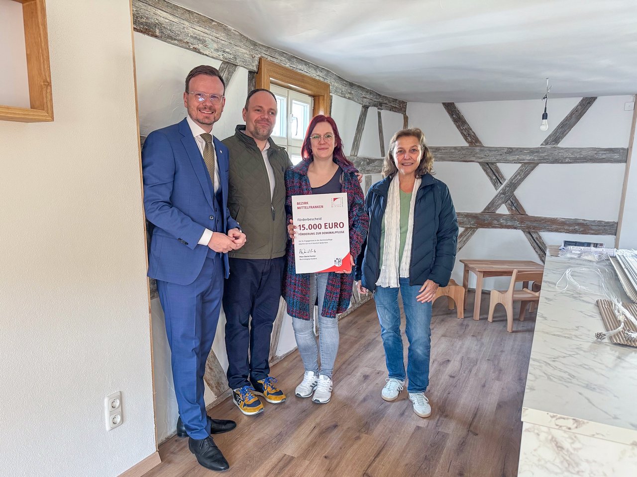 Gruppenbild im sanierten Gebäude mit Bezirkstagspräsidetn Peter Daniel Forster.
