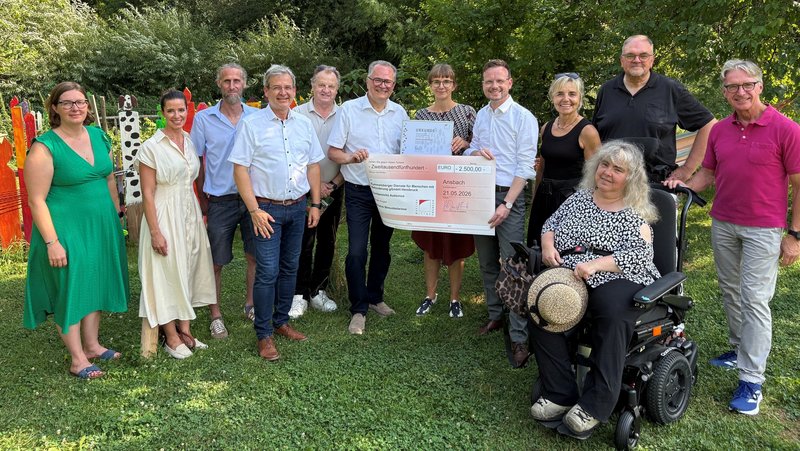 Gruppenbild der aufgezählten Personen bei der Übergabe des Inklusionspreises. Peter Daniel Forster und Karl Schulz halten den Scheck in die Kamera.