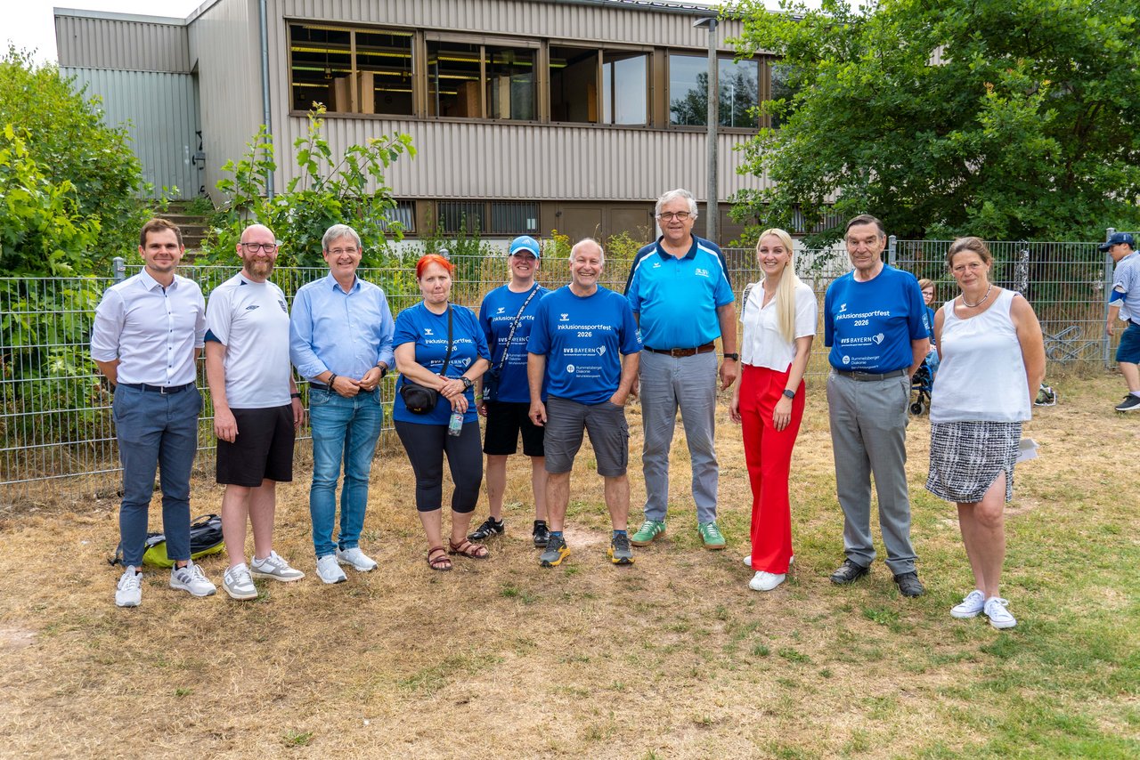 Gruppenfoto der aufgelisteten Personen auf dem Sportplatz.
