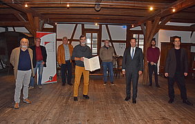 Küpstler der Original Hersbrucker Bücherwerkstätte mit Bezirkstagspräsident Armin Kroder bei der Verleihung der Urkunde.