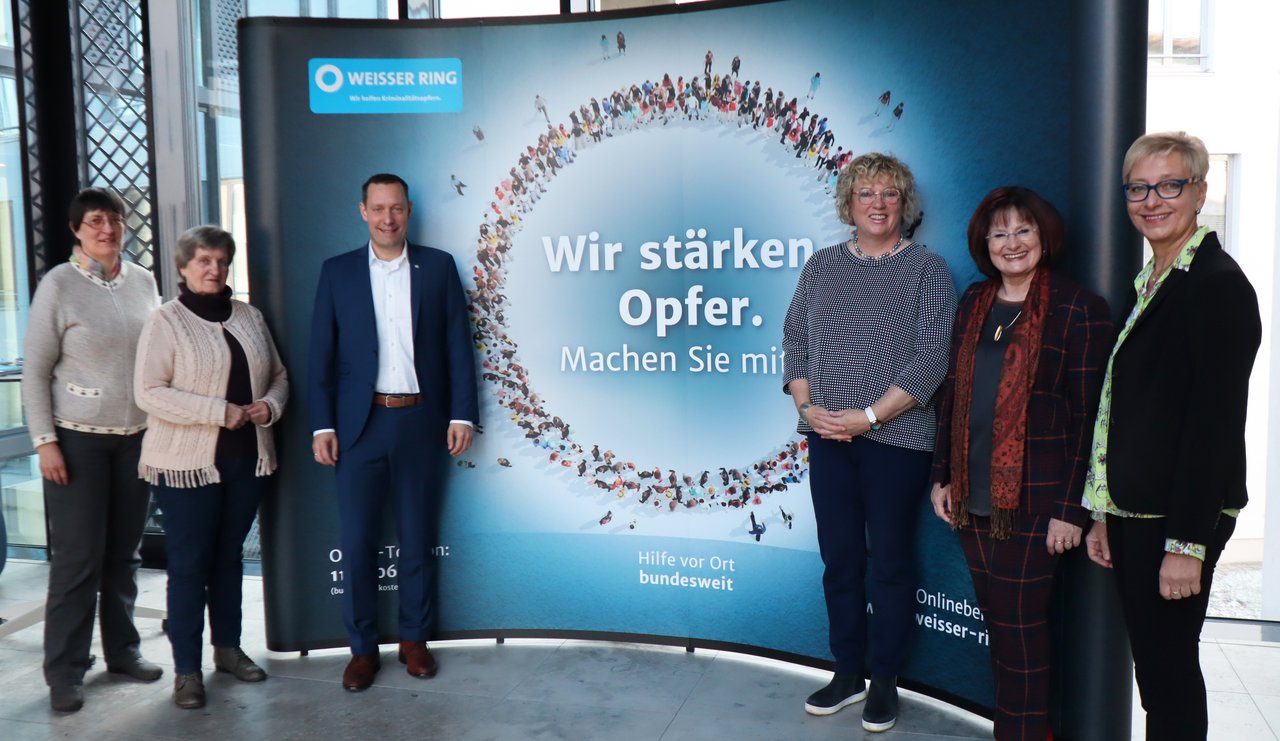 Gruppenfoto vor der Image-Wand des Weißen Rings.