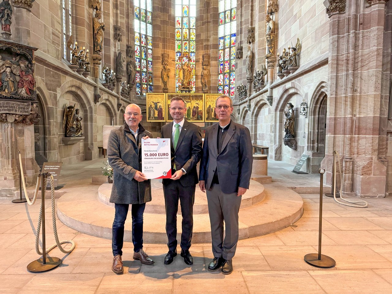 Drei Männer stehen vor dem Altar in einer Kirche
