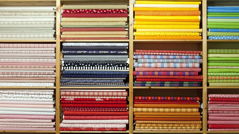 Foto auf einen Schrank voller Trachten, die zusammengefaltet aufeinandergestapelt sind.