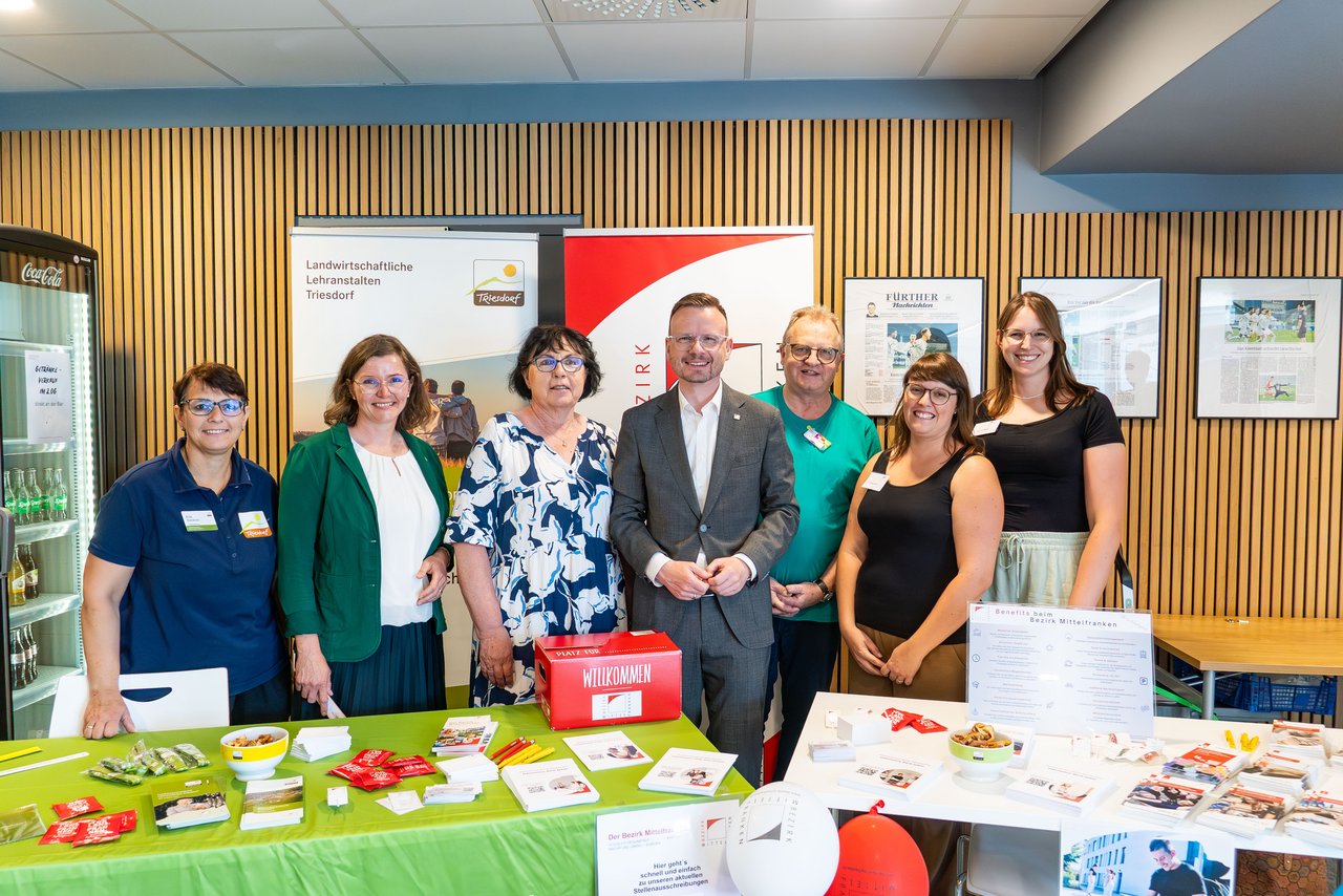Zahlreiche Leute stehen am Stand des Bezirks Mittelfranken und der Landwirtschaftlichen Lehranstalten Triesdorf und lachen in die Kamera.