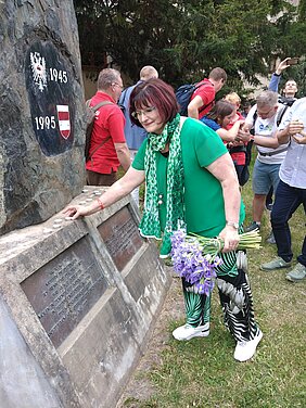 Christa Naaß entzündet eine Kerze am Denkmal zur Erinnerung der Vertrei-bung der Deutschen aus Brünn.  