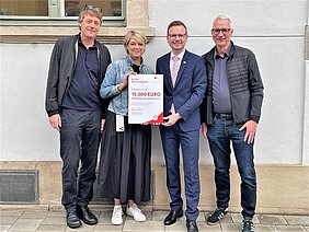Bezirkstagspräsident Peter Daniel Forster (3.v.l.) überreicht den Förderbescheid des Bezirks Mittelfranken