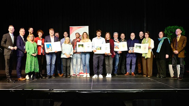 Gruppenbild einiger Preisträger der Denkmalprämierung 2024 auf der Bühne.