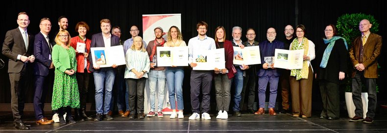 Gruppenbild einiger Preisträger der Denkmalprämierung 2024 auf der Bühne.