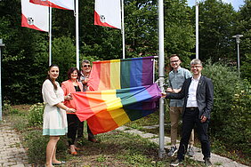 Christa Naaß mit weiteren Mitgliedern des Bezirkstags beim Hissen der Regenbogenfahne