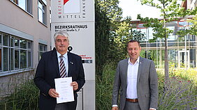 Jürgen Müller (links) mit Bezirkstagspräsident Armin Kroder (rechts) vor dem Bezirksrathaus in Ansbach.