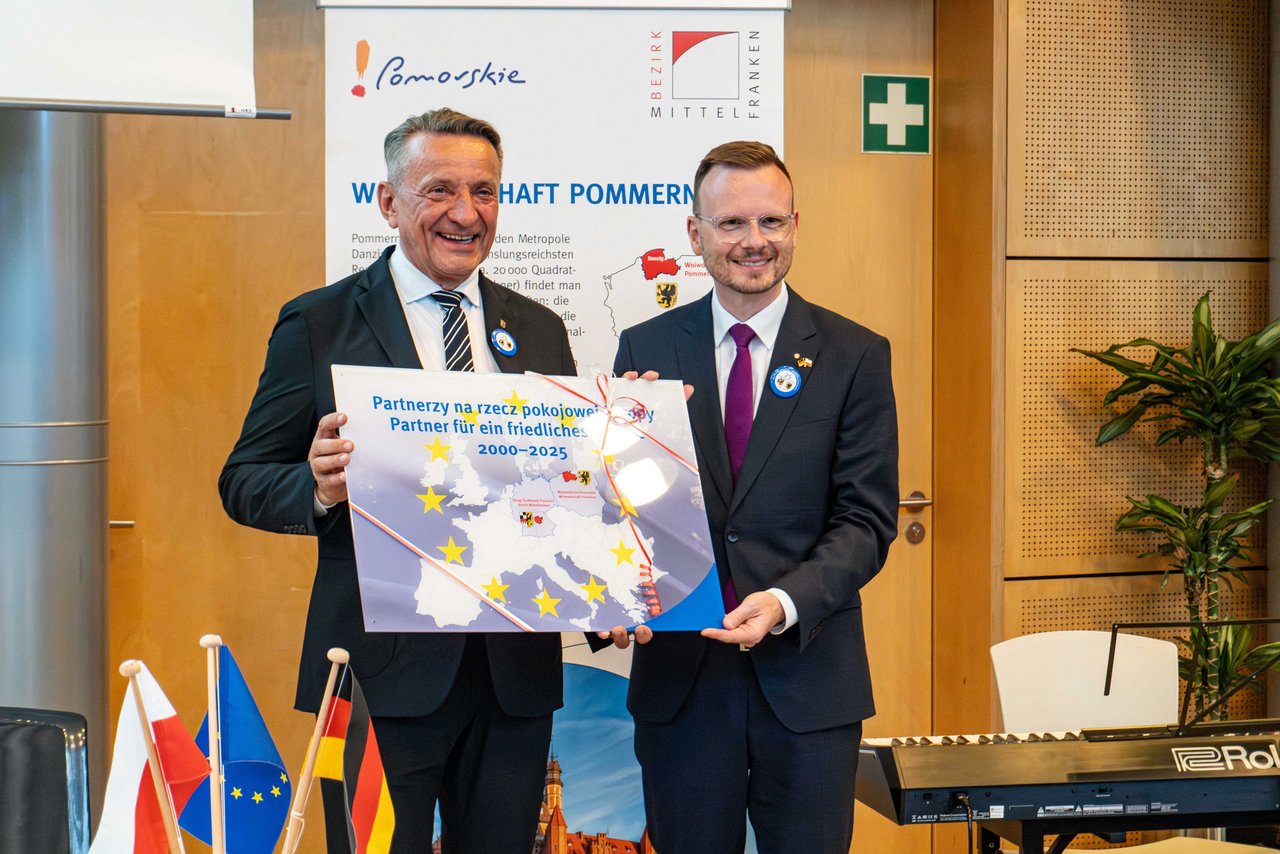 Peter Daniel Forster und Leszek Bonna bei der Übergabe eines Geschenkes.