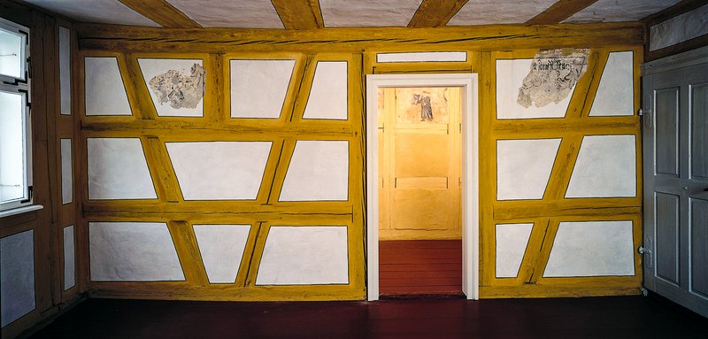 Bild aus einem Innenraum der historischen Laubhütte mit Blick auf ein schönes Fachwerk.