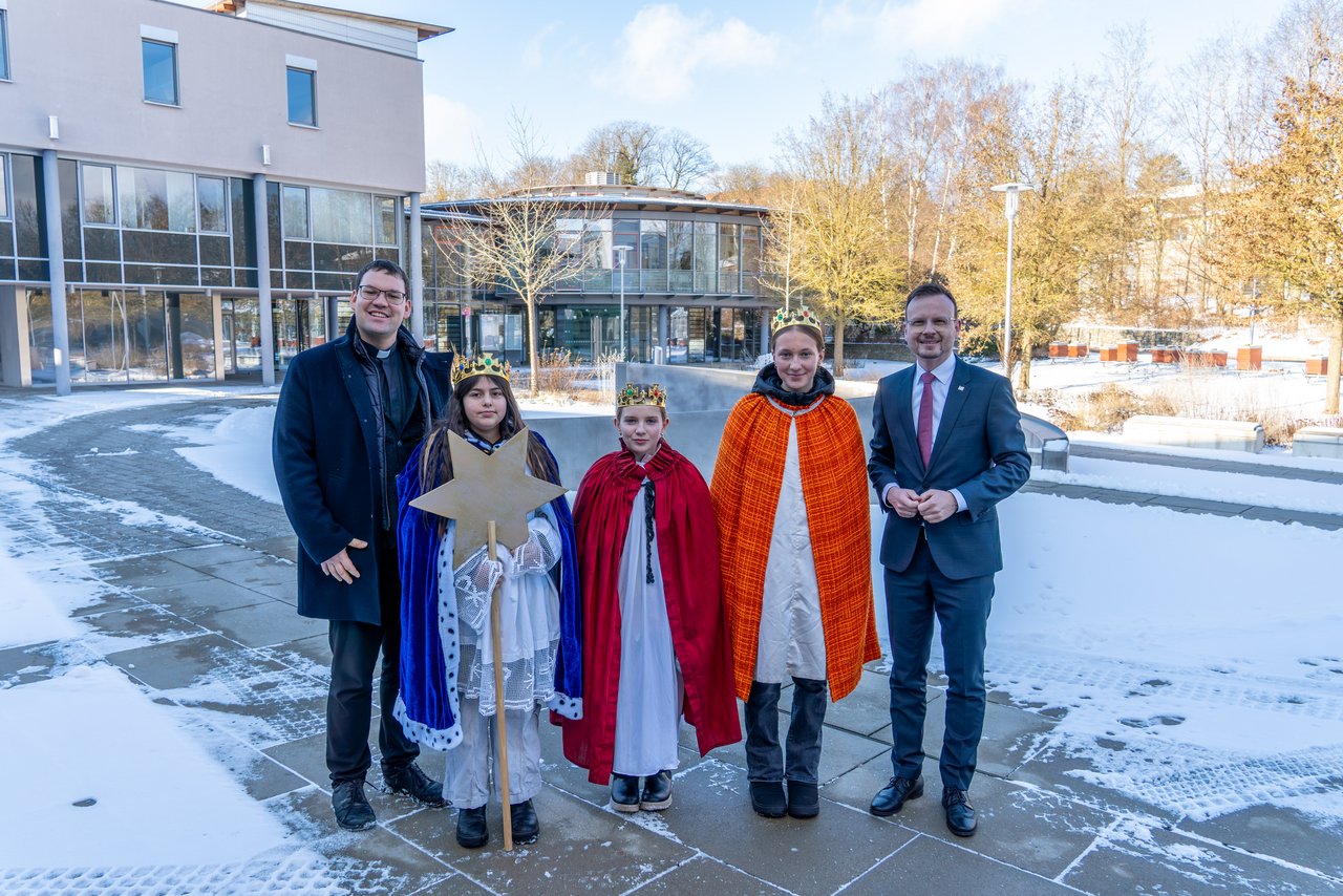 Menschengruppe steht vor Bezirksrathaus in Ansbach