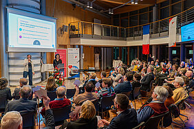 Menschengruppe sitzt im Saal