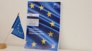 Foto des Jahresberichts mit einer Europa-Fahne im Vordergrund