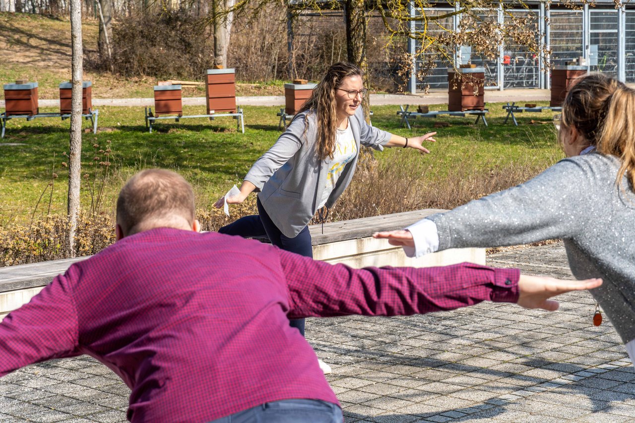 Eine Dame macht eine Übung vor, die Teilnehmer der aktiven MInipause machen die Übung nach.