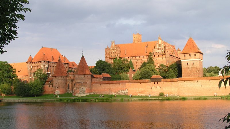 Aufnahme der Marienburg in Pommern. Davor fließt ein Fluss dabei.