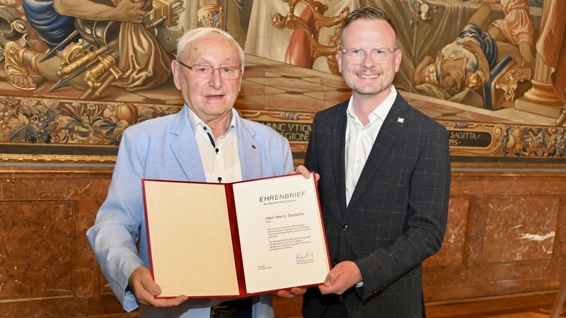 Gruppenbild von Bieberle und Forster. Bieberle hält dabei den verliehenen Ehrenbrief in den Händen und hält ihn in die Kamera.