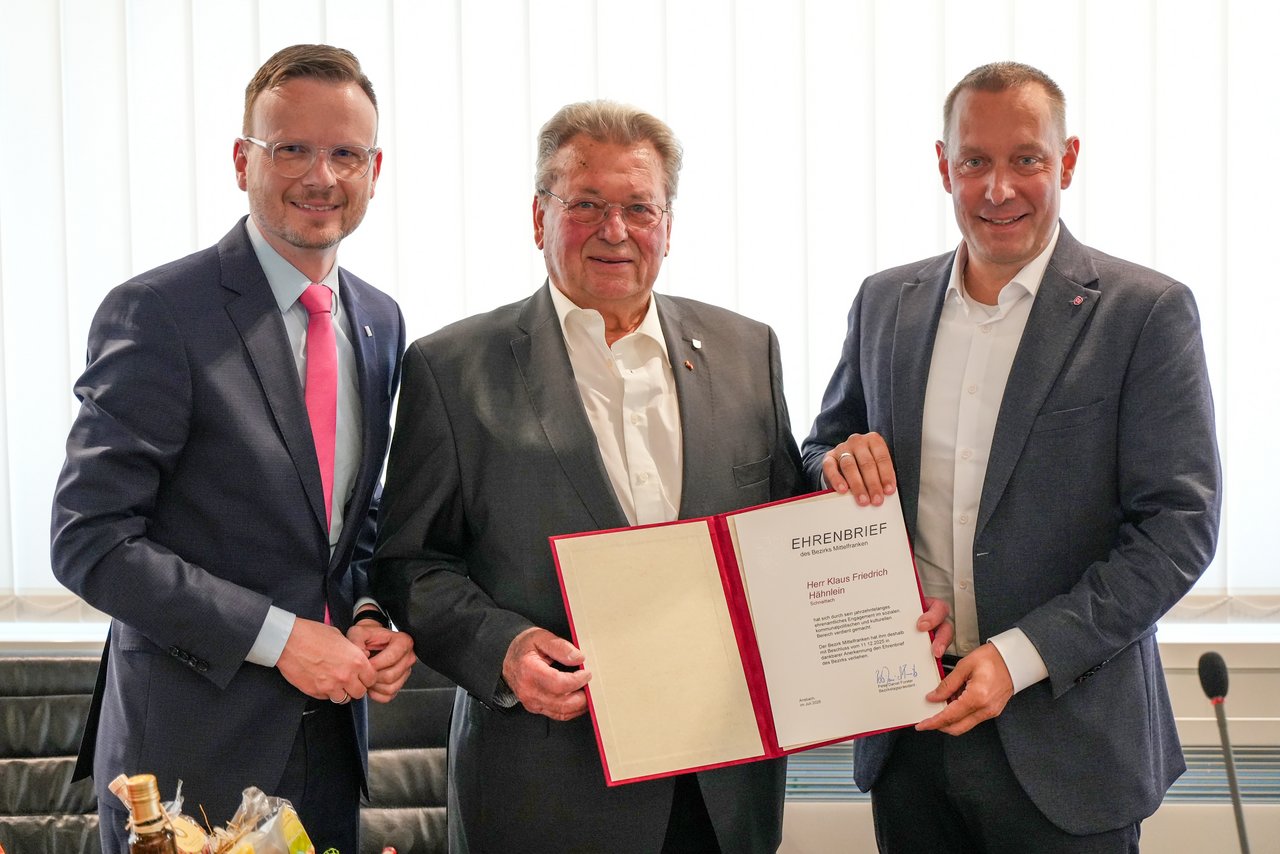 Gruppenfoto der aufgezählten Personen. Hähnlein hält dabei den verliehenen Ehrenbrief in die Kamera.