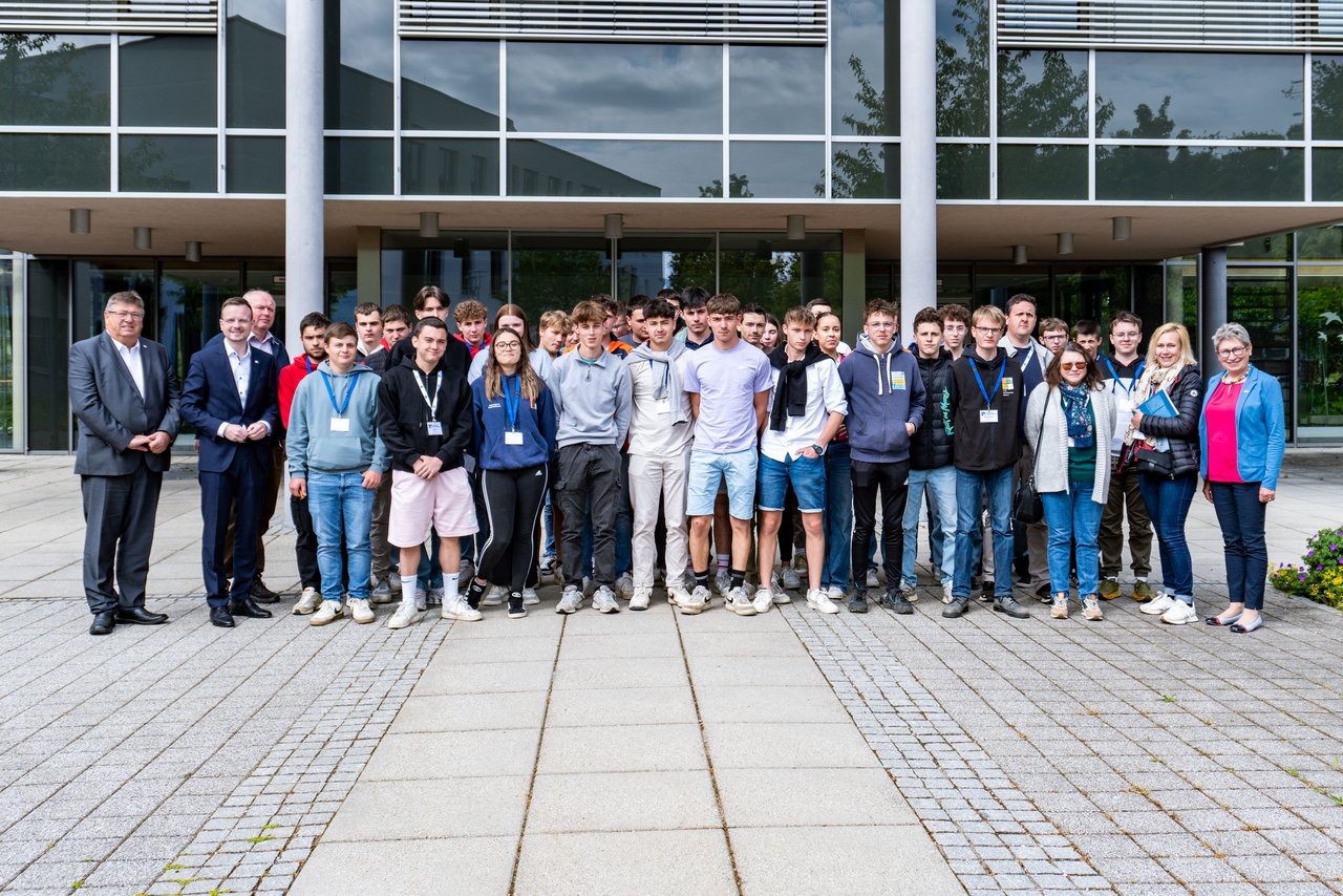 Gruppenbild der französischen Berufsschüler mit Bezirkstagspräsident Peter Daniel Fors-ter und Bezirksrat Hans Popp, Beauftragter für die Landwirtschaftlichen Lehranstalten Triesdorf, vor dem Ansbacher Bezirksrathaus.